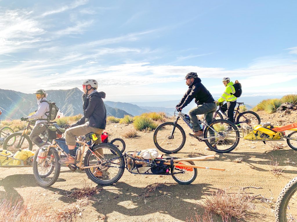 Trail work volunteers with bikes, trailers, and tools.